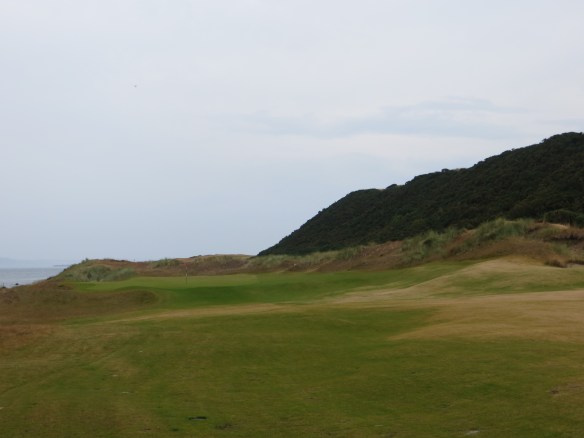 The back begins with holes framed by the dunes on the right and the sea on the left.